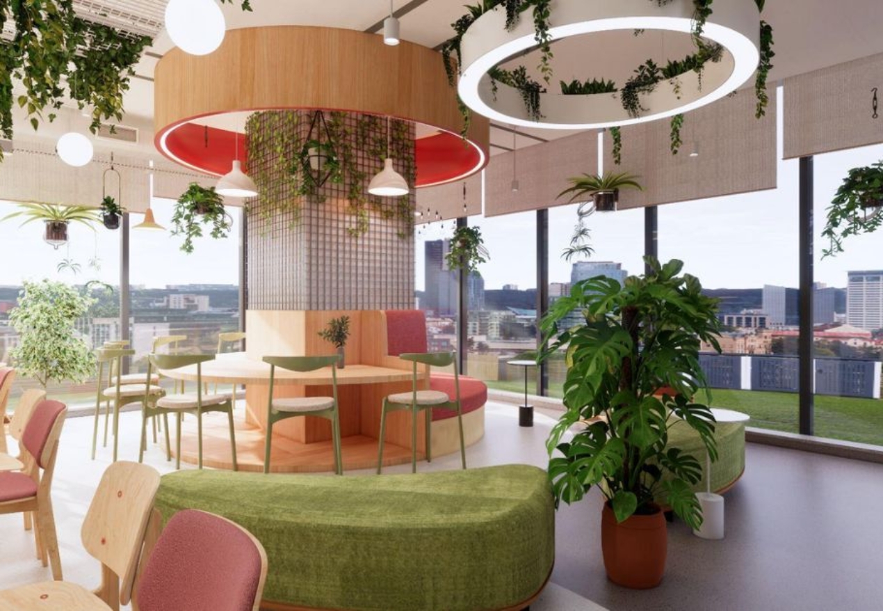 A collaborative workspace with natural light, greenery, and colleagues engaging in a discussion.