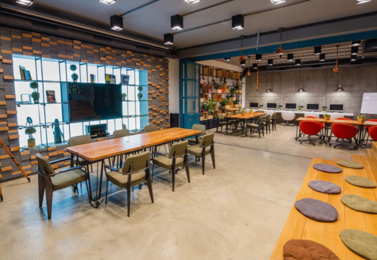 A modern coworking space in Hyderabad with professionals working at shared desks in a well-lit office.