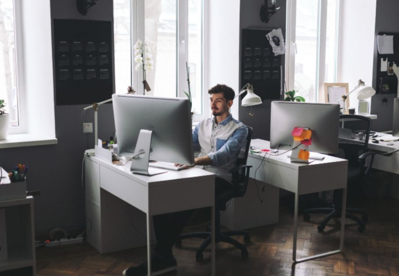 A professional working at a modern desk in a well-lit coworking space in Hyderabad, featuring an organized and productive office setup.